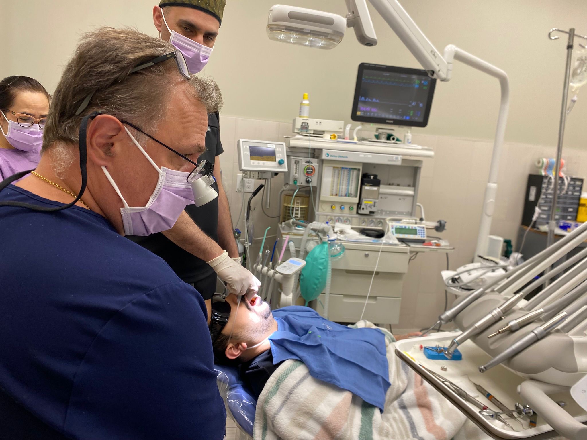 Dr. Koniouchine performing wisdom teeth extraction under sedation with anesthesiologist monitoring