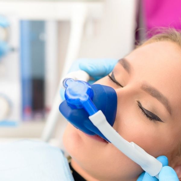 Patient comfortably breathing nitrous oxide laughing gas during dental treatment
